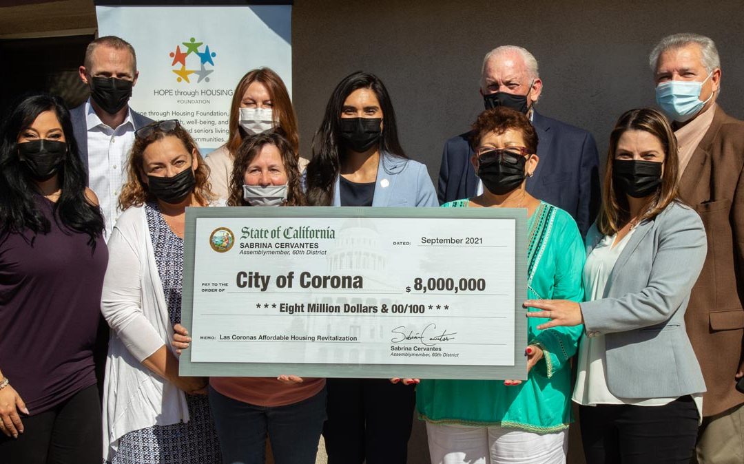 Assemblymember Sabrina Cervantes presents represetatives from National CORE and Hope through Housing with a check for $8 million