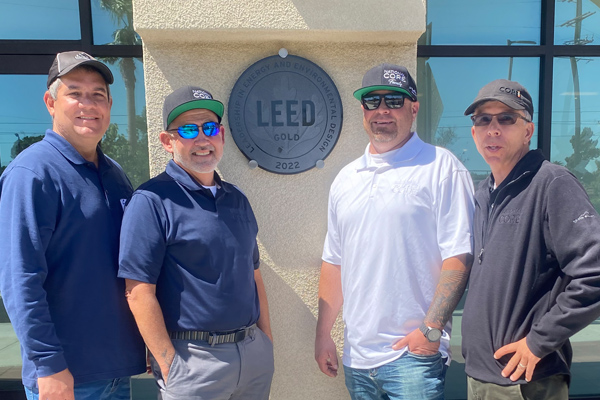 National CORE construction team members pose near the LEED Gold certification plaque.