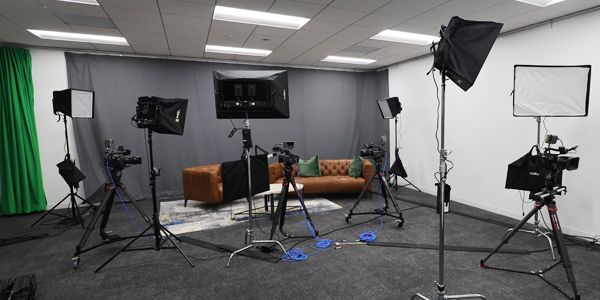 Interior photo of podcast studio with lighting and camera equipment